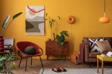 Sıcak ve rahat oturma odasının iç mimarisi şık kilim kilim halılar, ahşap büfe, bitki, sarı duvar, kırmızı koltuk, kahverengi kanepe ve kişisel aksesuarlar. Ev dekoru. Şablon.