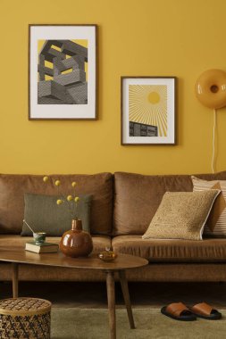 Sarı oturma odasının iç tasarımı poster çerçevesi, kahverengi kanepe, ahşap sehpa, terlik, yeşil halı, sepet, turuncu lamba ve kişisel aksesuarlar. Ev dekoru. Şablon.