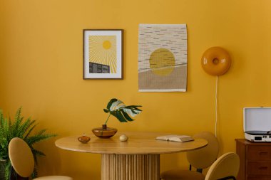 Yemek odasının sıcak ve rahat kompozisyonu poster çerçevesi, kilim halı, yuvarlak masa, sarı sandalye, duvar, yapraklı vazo, kitaplar ve kişisel aksesuarlarla. Ev dekoru. Şablon.