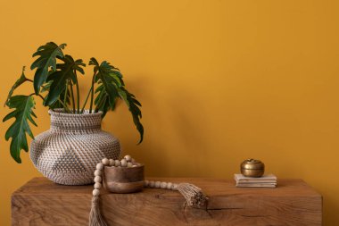 Minimalist kompozisyonu sıcak ve rahat oturma odası içinde fotokopi alanı, sarı duvar, yapraklı vazo, altın tabut, ahşap büfe ve kişisel aksesuarlar. Ev dekoru. Şablon.