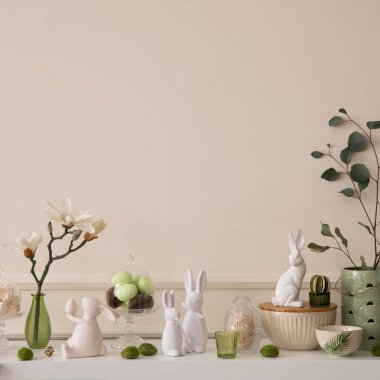 Interior design of easter living room interior stylish sideboard, colorful easter eggs, easter bunny sculpture, vase with leaves, magnolia and personal accessories Home decor. Template.