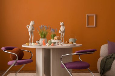 Seramik tavşan heykelcikleri, renkli yumurtalar ve çağdaş masa düzeninde bahar çiçekleri ile şenlikli Paskalya düzenlemesi