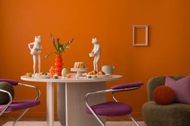 Modern Paskalya yemeği sahnesi. Heykeltraş heykelcikleri, canlı laleler ve koyu turuncu arka plan..