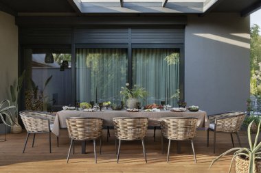 Terasların estetik yapısı masa, sandalye, bahçe mobilyaları, çiçekli vazo, büyük pencere, meyve, yiyecek, sofra takımı, bitkiler ve kişisel aksesuarlar. Ev dekoru. Şablon.