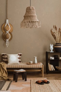 Rahat kanepesi, ahşap lambası, halısı ve aksesuarları olan modern oturma odasının şık bir iç mekanı..