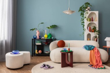 Modern and colorful interior of living room with design boucle sofa, mock up poster, shelf, plants, decorations and personal stuff. Home decor.	