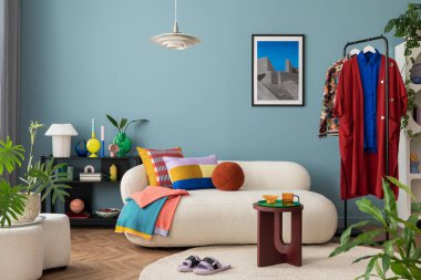 Modern and colorful interior of living room with design boucle sofa, mock up poster, shelf, plants, decorations and personal stuff. Home decor.	