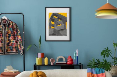 Modern and colorful interior of living room with design boucle sofa, mock up poster, shelf, plants, decorations and personal stuff. Home decor.	