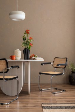 Minimalist bej yemek odasının iç tasarımı masa, şık sandalyeler, vazoda çiçekler, lamba, dekorasyon ve kişisel aksesuarlar. Şablon. Ev dekoru.
