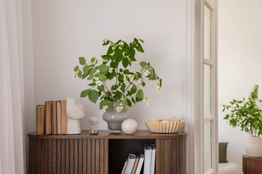 Tarafsız tonlara sahip şık bir oturma odası, rahat bir kanepe, zeytin yeşili yastıklar ve duvarda sanatsal model çerçeve baskısı. Sıcak ev dekorasyonu. Şablon.