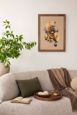 Rahat ve huzurlu bir yaşam alanı bej bir kanepe, yeşillik ve doğadan esinlenilmiş bir çerçeve baskısı ile huzurlu bir ortam yaratıyor. Şık bir ev dekoru. Şablon.
