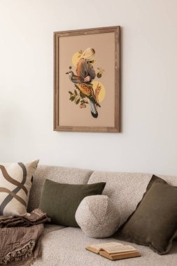 Tarafsız tonlara sahip şık bir oturma odası, rahat bir kanepe, zeytin yeşili yastıklar ve duvarda sanatsal model çerçeve baskısı. Sıcak ev dekorasyonu. Şablon.