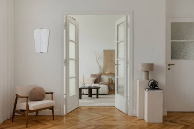 Yüzyıl ortası modern koltuğu, hafif ışıklandırması ve nötr tonu olan rahat, minimalist bir yaşam alanı. Odada cam kapılar, desenli duvarlar ve zarif bir dekor var. Huzurlu ve davetkar bir atmosfer yaratıyor..