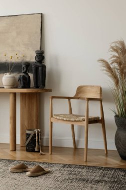 Dekoratif vazolar, mumlar ve heykellerle süslenmiş ahşap bir konsol masası ve sandalye içeren estetik iç tasarım. Büyük, soyut bir resim modern bir dokunuş ekler. Havalı bir yer. Şablon.