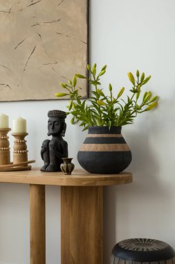 Etnik heykelleri olan siyah beyaz bir dekor. Etnik esinlenilmiş heykel ve vazoların yer aldığı şık bir düzenleme, çarpıcı bir karşıtlık için tarafsız bir zemin oluşturur.