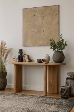 Sanatsal dekor elementleriyle modern konsol masası dengeli ve estetik bir iç mekan yaratıyor. Boho ev dekorasyonu. Tabloları düzenle.