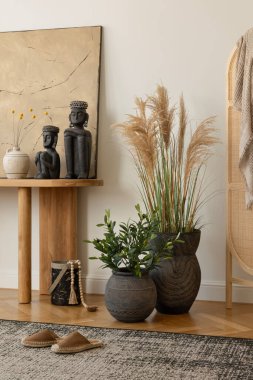Sanatsal dekor elementleriyle modern konsol masası dengeli ve estetik bir iç mekan yaratıyor. Boho ev dekorasyonu. Tabloları düzenle.