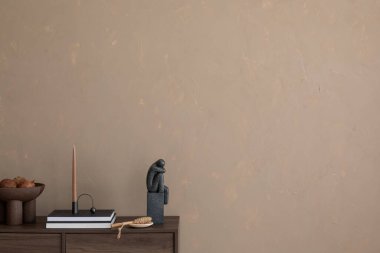 İç mimari desenli bej bir duvar, modern heykeller ve ahşap bir büfede eşsiz bir mum tutacağı. Toprak tonları ve çağdaş dekorun mükemmel bir karışımı. Şablon. Boşluğu kopyala.