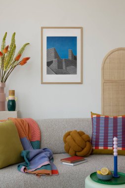 Renkli geometrik yastıklarla vurgulanmış açık bej koltuklu modern yaşam alanı, yumuşak bir atış ve eşsiz dekor elementleri..