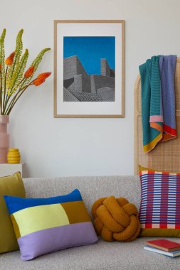 Açık bej koltuklu, renkli geometrik yastıklarla vurgulanmış, yumuşak bir atış ve eşsiz dekorasyon elementleriyle modern yaşam alanı. Ev dekoru.