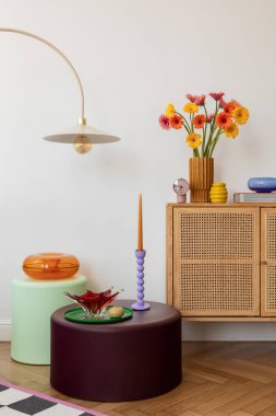 Yüzyılın ortalarında çiçek vazosu, renkli mumlar ve canlı bir duvar baskısı olan modern büfe. Minimalist ama eğlenceli iç dekorasyon.
