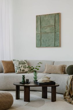 A modern, minimalist interior with a large sofa and natural accents. Soft greens bring harmony to the space, creating an elegant, calming atmosphere.	
