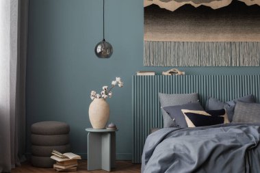 Pamuk saplı modern bir vazoya yakın plan, dinlendirici bir yatak odasındaki komodinin yanında..