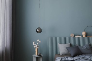 Kaburgalı yatak başlığı, katmanlı yastıkları ve heykel dekoru olan sofistike bir yatak odası. Sessiz mavi tonlar ve doğal malzemeler, uyumlu bir geri çekilme yaratır..