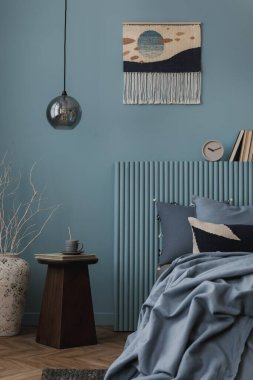 Yumuşak mavi paleti, soyut dekoru ve organik dokuları olan modern bir yatak odası. Çağdaş tasarımı sıcaklıkla dengeleyen dikkatlice biçimlendirilmiş bir ayar