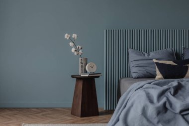 Katmanlı yatağı, açık bir kitabı ve doğal dokuları olan rahat bir yatak odası. Sanatsal duvar asılı ve heykel dekoru zarif ama davetkar bir atmosfer yaratıyor..