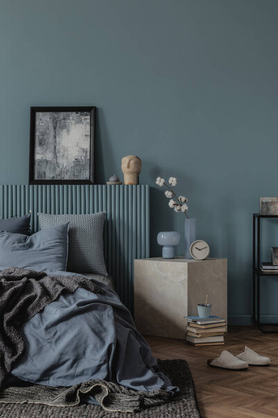 Интерьер современной спальни с голубыми цветами, естественным освещением, декорациями, художественными произведениями и персноальными аксессуарами. Декор дома. 