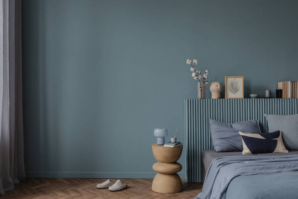 Уютная спальня со стильным изголовьем, приглушенными голубыми постельными принадлежностями и художественным сочетанием декора, книг и натуральных текстур.