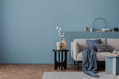 Mavi duvarları, rahat bir kanepesi ve ahşap zemini olan minimalist oturma odası. Huzurlu ve dengeli bir modern iç mekan..