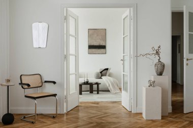 Minimalist baston koltuklu, heykel desenli ve yumuşak tonlu zarif bir yer. Modern tasarım ve sanatsal aksanların sakin bir karışımı..