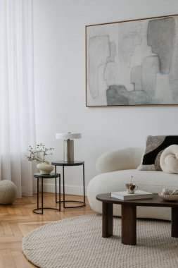 Tarafsız tonlara, heykel biçimlerine ve yumuşak mobilyalara sahip, sakin ve davetkar bir ortam yaratan, dikkatlice tasarlanmış bir salon..