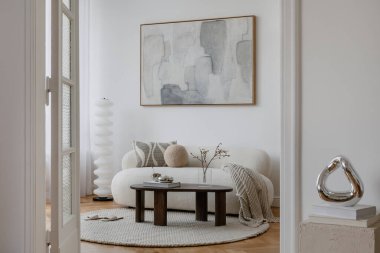 Kıvrımlı beyaz bir kanepesi, dokulu yuvarlak bir halısı ve sakin bir atmosfer yaratan yumuşak nötr bir dekoru olan minimalist yaşam alanı..
