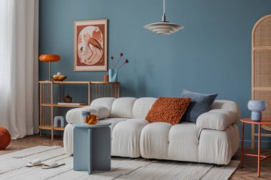 Tarafsız tonlu oturma odası köşesi katmanlı tekstil, yastıklı kanepe ve sakin bir ortam için minimalist dekor..