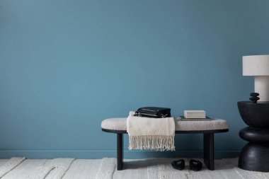 İçi şatafatlı poster çerçevesi, gri koltuk, mavi duvar, siyah konsol, şık lamba, çiçekli vazo, ahşap tezgah, bank ve kişisel aksesuarlar ile dolu. Ev dekoru. Şablon.