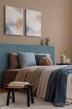 Zarif soyut sanat eserleri, heykeltraş sehpası ve sofistike ve rahatlatıcı bir alan için dokulu tekstil içeren, sessiz bir paleti olan rafine yatak odası..