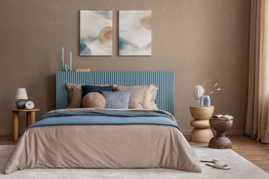Serene yatak odası, mavi bir karyola başlığı, desenli yastıklar ve modern ve organik dekoratif elementlerin karışımı..
