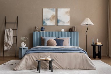 Soyut sanat eserleriyle minimalist yatak odası dekoru yumuşak tonlu yatak ve organik şekilli başucu aksesuarları..