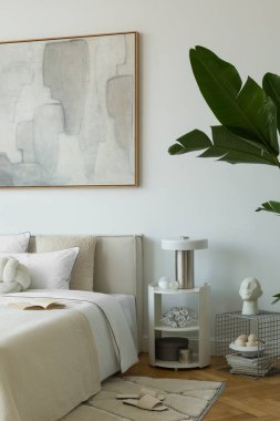 Yumuşak nötr tonları olan parlak minimalist yatak odası yatağın üzerinde büyük soyut resim ve beyaz perdelerin arasından akan doğal ışık..