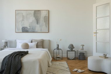 Yumuşak nötr tonları olan parlak minimalist yatak odası yatağın üzerinde büyük soyut resim ve beyaz perdelerin arasından akan doğal ışık..