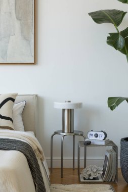 Yumuşak nötr tonları olan parlak minimalist yatak odası yatağın üzerinde büyük soyut resim ve beyaz perdelerin arasından akan doğal ışık..