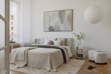 Minimalist yatak odası soyut sanat eserleri, nötr yatak ve yumuşak gün ışığında katmanlı tekstil. Tarz ev dekoru