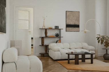 Yumuşak dokuları, geometrik rafları ve rahat minimalist yerleşimi olan İskandinav esinlenilmiş oturma odası.