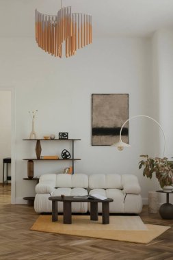 Modern oturma odası, soyut sanat eserleri, beyaz buket kanepe ve sıcak, çağdaş bir ortamda grafik detaylar..