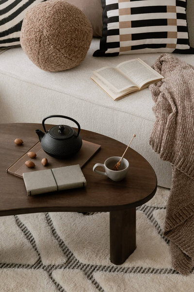 Close up of coffee table. Bright living space with wooden flooring and woven furniture. A balance of natural textures and soft lighting.