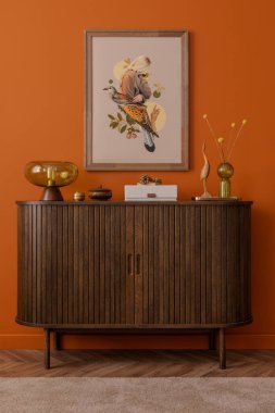 Ahşap büfeden ustaca bir iç mekan, kolaj duvar sanatı, dekorasyon ve kehribar cam lambayı ılık toprak tonlarda taklit et.. 