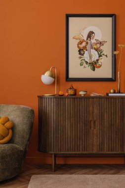 Koyu renk ahşap bir dolabın üstündeki duvar sanatı ile modern iç mekan. Çağdaş yeteneği olan sonbahardan esinlenilmiş palet.